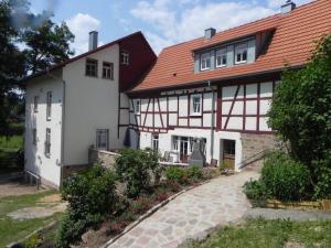 Kassel bei Biebergemünd的住宿－Ferienwohnung Tiererlebnishof Obermühle，白色的房子,有红色的屋顶和车道