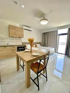 cocina y comedor con mesa de madera y sillas en For Rest Aparthotel, en St Paul's Bay