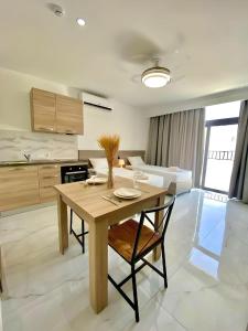 una cucina e una sala da pranzo con tavolo e sedie in legno di For Rest Aparthotel a San Pawl il-Baħar