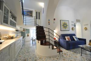 a living room with a blue couch and a spiral staircase at Casa Patty...Breath-taking view! in Positano