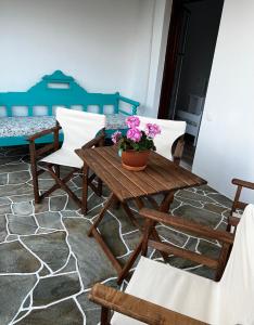 ein Holztisch und Stühle mit einer Topfpflanze darauf in der Unterkunft Sifnos Valley in Faros