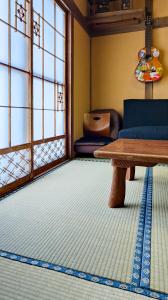 a living room with a table and a couch at Yukiumi House in Kamikawa