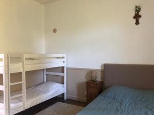 a bedroom with a white bunk bed and a cross on the wall at Gîte du Sacré-Coeur - 25 mn du Puy du fou in Saint-Aubin-de-Baubigné