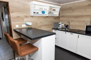 cocina con armarios blancos y encimera negra en Bjarg Apartments en Grundarfjordur