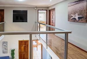 a staircase in a home with a glass railing at Ballito Backpackers in Ballito