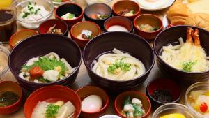 a group of bowls filled with food on a table at Dormy Inn Takamatsu in Takamatsu