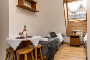 Habitación con mesa, cama y ventana en Willa Danuśka -Znana i Lubiana, en Zakopane