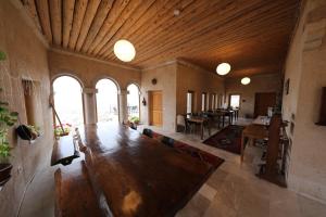 a large living room with a large wooden table at Helike Cave Suites in Uçhisar