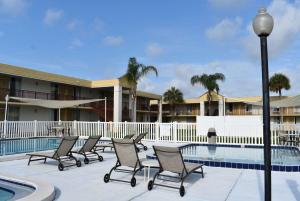a group of chairs sitting next to a swimming pool at Super 8 by Wyndham Ocala I-75 in Ocala