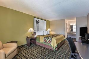 a small hotel room with a bed and a desk at Super 8 by Wyndham Ocala I-75 in Ocala