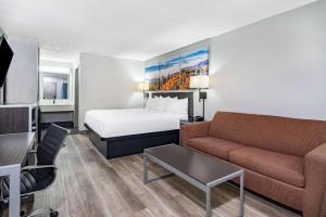 a hotel room with a bed and a couch at Days Inn by Wyndham Hamilton in Hamilton
