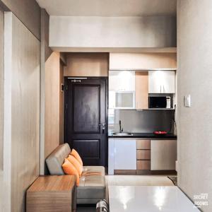 ein kleines Wohnzimmer mit einem Sofa und einer Küche in der Unterkunft Ciumbuleuit Apartment by Secret Rooms in Bandung