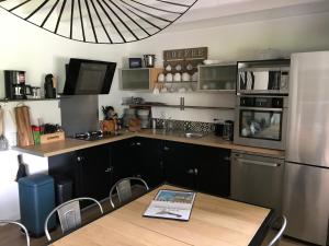 a kitchen with a table and a refrigerator at Gîtes du Moulin à Tan à Saché 37 in Saché +20 photos