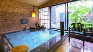 uma grande piscina interior num quarto com janelas em Dormy Inn Takamatsu em Takamatsu