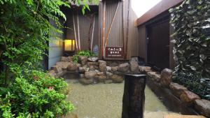 a garden with rocks and a entrance to a building at Dormy Inn Takamatsu in Takamatsu