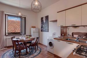 a kitchen with a table and a sink and a refrigerator at Vedetta Townhouse - camere e appartamenti nel centro storico by Be Vedetta in Scarlino