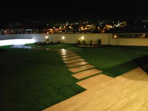 einen Garten in der Nacht mit einem Pfad im Gras in der Unterkunft Departamento confortable en Quito in Quito