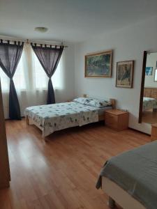 1 dormitorio con 2 camas y suelo de madera en IN Kala en Rijeka