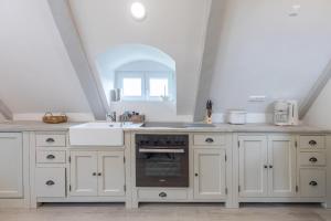 a kitchen with white cabinets and a sink at Nordisch noble Lebensart WE 2 in Bargum