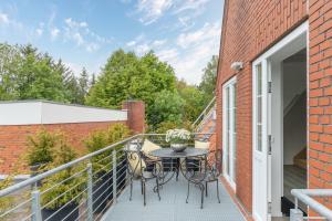a patio with a table and chairs on a balcony at Nordisch noble Lebensart WE 1 in Bargum