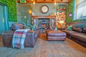 een woonkamer met lederen meubels en een open haard bij Waterfall Country Escape Entire Venue Sleeps 19 - Brecon Beacons National Park Wales in Coelbren