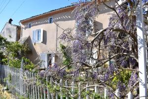 a house with wisteria on the side of it at L'Occitania Chambre d'hotes in Puivert