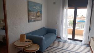 a living room with a blue couch and a balcony at El balcón de riells in L'Escala