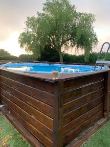 une clôture en bois autour d'une piscine avec une chaise dans l'établissement Casona cantabra con piscina a 3 km de playas. Ideal familias., à Liencres