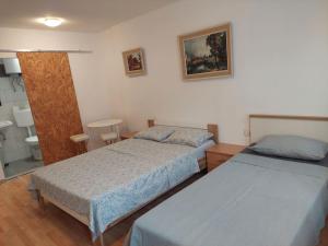 a bedroom with two beds and a mirror at IN Kala in Rijeka