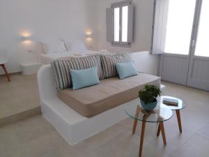 a living room with a white couch and a table at Spectacular view Caldera St V in Megalochori