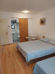 a bedroom with two beds and a bathroom at IN Kala in Rijeka