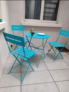 a blue table and two chairs and a table and chairs at Appartement Les 7 Roses in Vitry-le-François