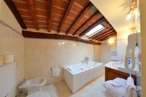 y baño con bañera y lavamanos. en Hotel San Michele, en Cortona