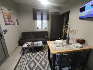 sala de estar con mesa y sofá en Music Reflections Apartment near Nafplio, en Nea Kios
