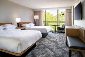 a hotel room with two beds and a balcony at Sheraton Orlando North in Orlando