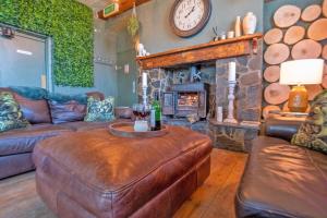 a living room with a couch and a fireplace at Waterfall Country Escape Entire Venue Sleeps 19 - Brecon Beacons National Park Wales in Coelbren