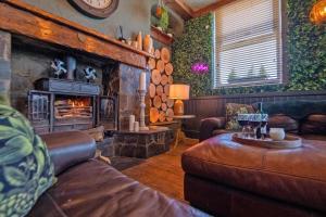 - un salon avec un canapé et une cheminée dans l'établissement Waterfall Country Escape Entire Venue Sleeps 19 - Brecon Beacons National Park Wales, à Coelbren
