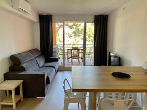 uma sala de estar com um sofá e uma mesa em BADINE BEACH 5p Plage piscine balnéo clim jardin éxotique em Hyères