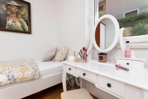 ein weißes Schlafzimmer mit einem Bett und einem Spiegel in der Unterkunft Seafront Maris by EL-PI TOURS in Dobrinj + 82 Fotos