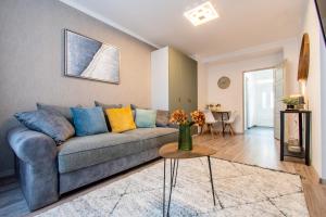 sala de estar con sofá azul y mesa en Alex Apartman, en Szombathely