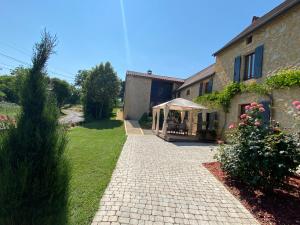 a brick pathway leading to a house with a tent at Cottage de La Mothe in Marnac