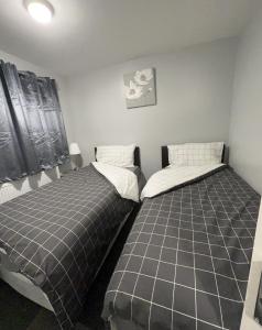two beds sitting next to each other in a bedroom at Mona's Home in Dagenham +46 photos