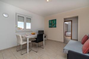 - un salon avec une table, des chaises et un lit dans l'établissement Apartmani Grga, à Trogir