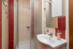 La salle de bains est pourvue d'un lavabo et d'une douche. dans l'établissement Apartmani Grga, à Trogir