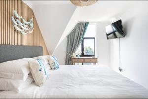 una camera con letto bianco e TV di 5 mins from the Eden Project Baybreeze Holiday Apartment, Sea Views, Super Kingsize Beds a St Austell