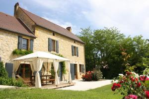 un edificio con un cenador frente a él en Cottage de La Mothe, en Marnac