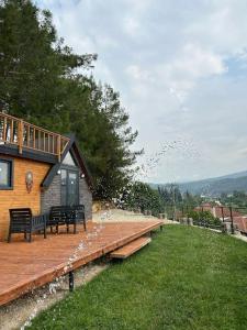 a house with benches on a wooden deck at Orman ile iç içe ağaç ev in Ula