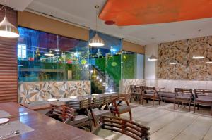 a restaurant with wooden tables and chairs and a large window at Hotel Sallow Royal Suites in Amritsar