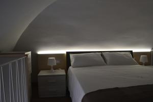 1 dormitorio con cama blanca y techo blanco en MargaretHome, en Gravina in Puglia
