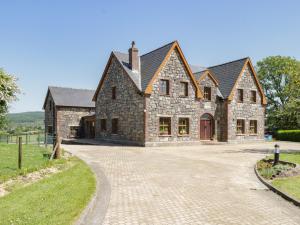 a large stone house with a driveway at Ballyboy View in Manorhamilton